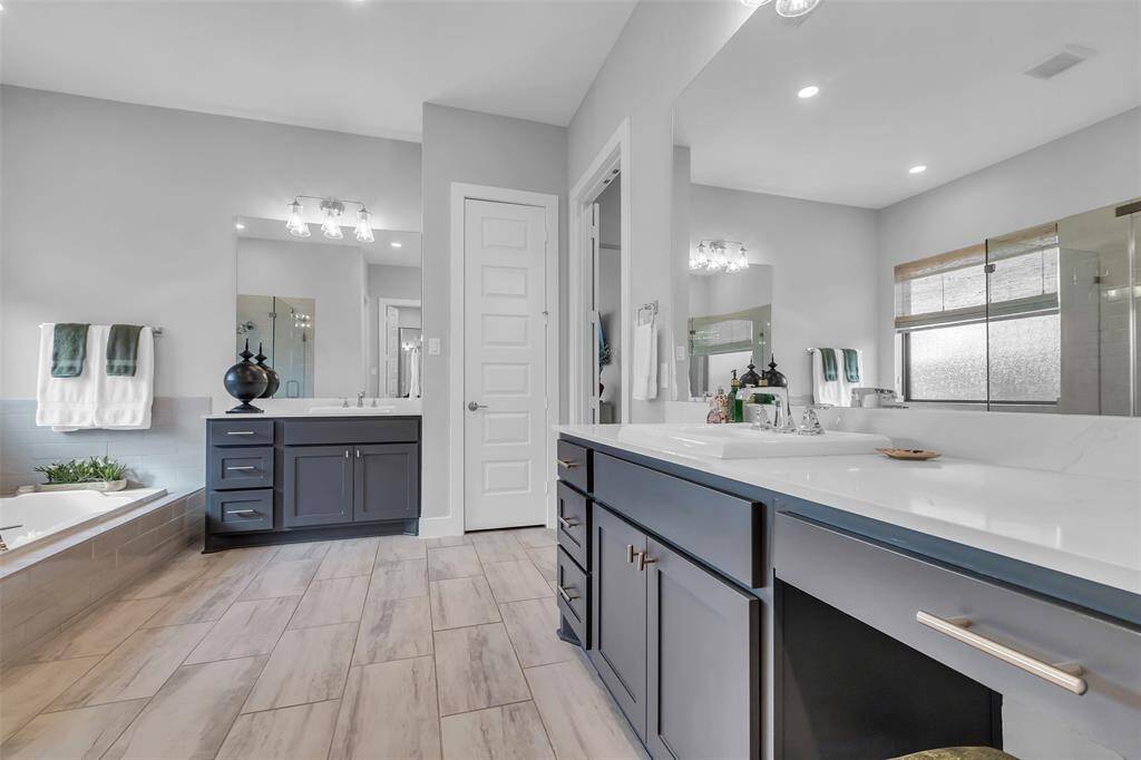The luxurious primary bathroom has dual vanities, a large frameless shower and soaking tub. Dual walk-in closet ensures plenty of storage space.