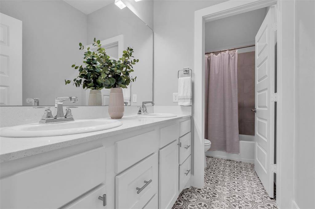 Hall bath with upgraded tile serves the additional two secondary bedrooms.
