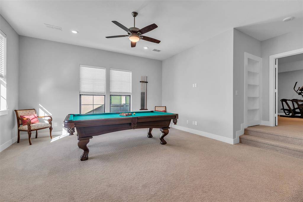 Large game room can accommodate an 8-foot pool table. Check out the bookcase, there's hidden storage behind it!