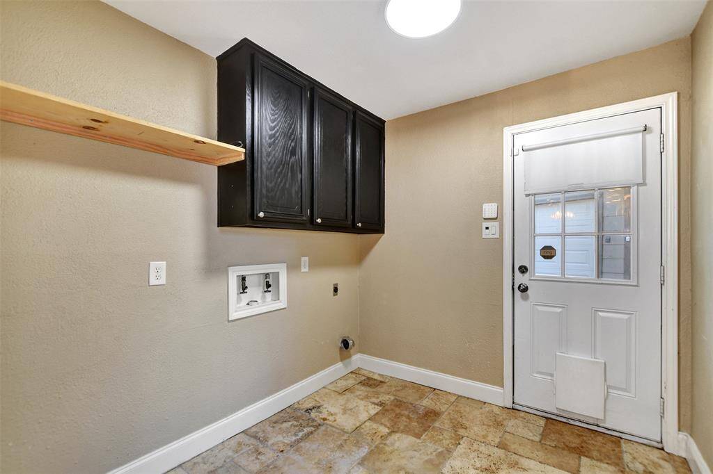 Spacious utility room with a doggy door. Easy access to detached garage and garage apartment.