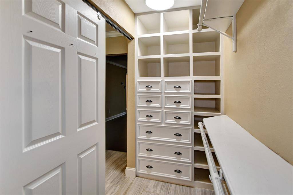 Primary closet with well-organized walk-in closet with ample shelving, drawers, and hanging space, providing efficient storage solutions.