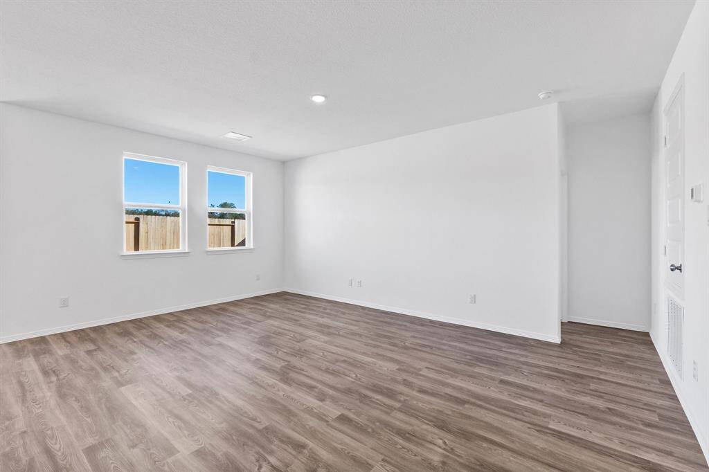 Living area. The passage on the right leads to the Primary bedroom. Blinds have been installed.