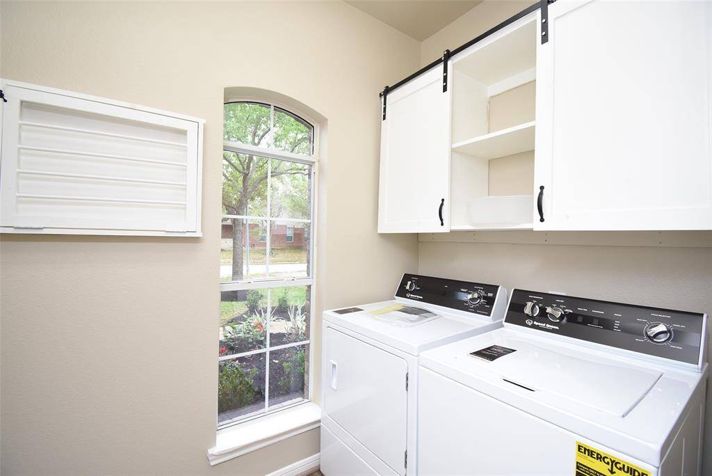 This bright and functional laundry room is designed for convenience! With ample storage, a large window for natural light, and a washer and dryer included, keeping up with laundry has never been easier.