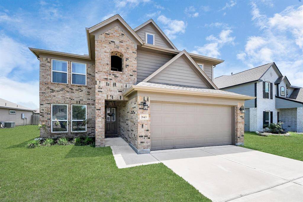 Beautiful two-story home with brick and stone elevation, well-maintained front yard, and a spacious driveway