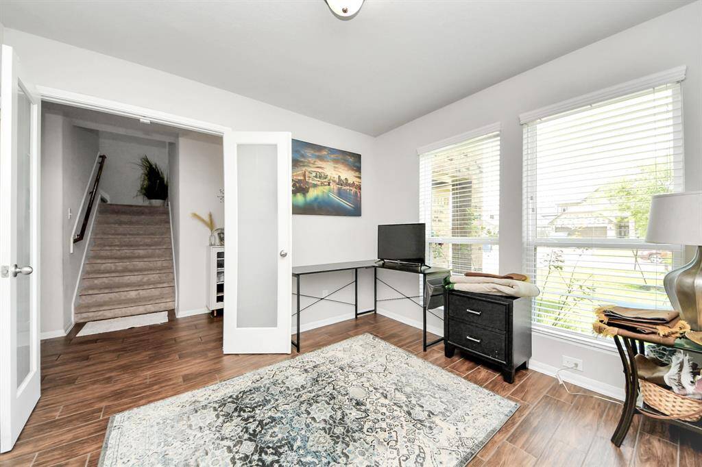 Bright multi-use room with tile flooring, ideal for an office or flex space.
