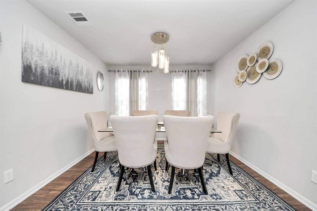 Convenient guest half bathroom located on the main floor, featuring a pedestal sink and updated lighting.