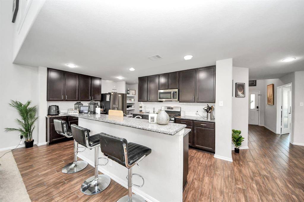 Dedicated laundry room with upper shelving and tile flooring.