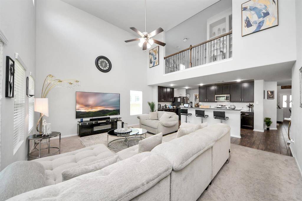 Spacious primary bedroom with large windows and neutral carpet.