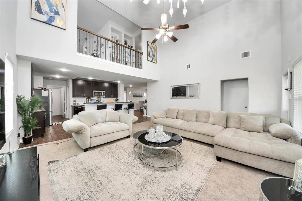 Spacious primary bedroom with large windows and neutral carpet.