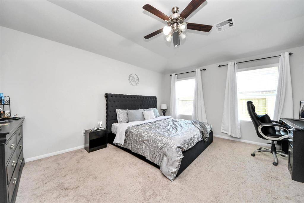 Dual vanity, separate soaking tub and glass-enclosed shower with wood-look tile flooring.