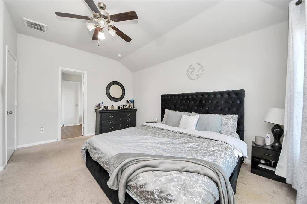 Dual vanity, separate soaking tub and glass-enclosed shower with wood-look tile flooring.