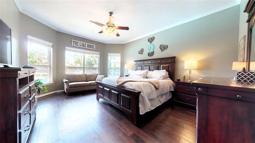 Retreat to comfort and privacy in this spacious primary suite, ideally located at the rear of the home for added tranquility. The bedroom features rich hardwood flooring, soft neutral tones, and a bay window overlooking the backyard and pool—perfect for a cozy sitting area or reading nook.