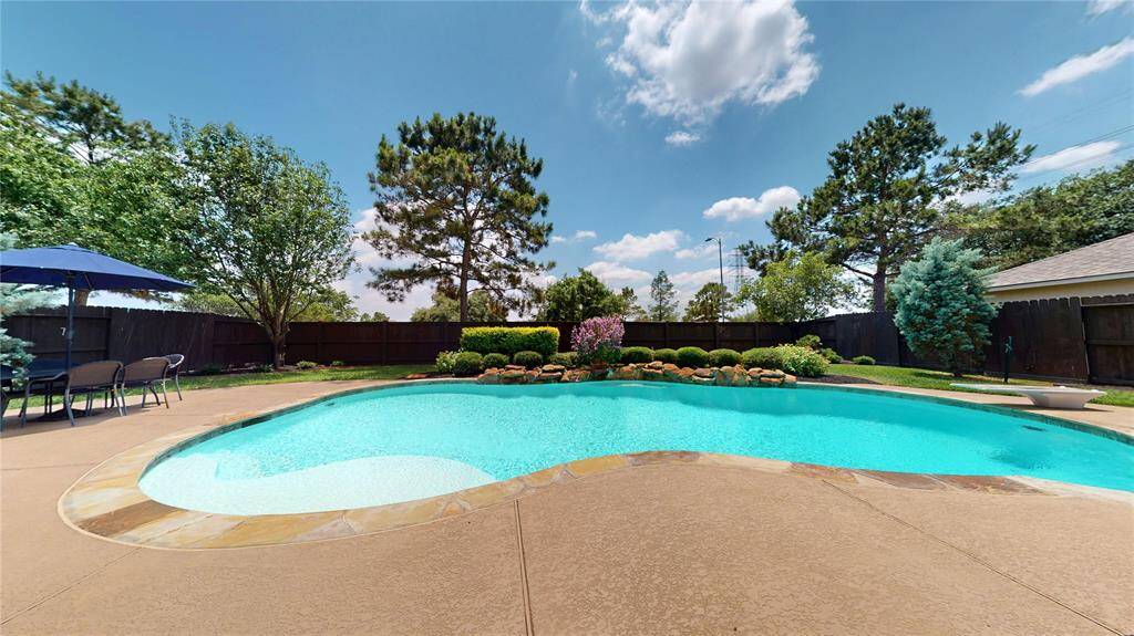 This stunning backyard is your private oasis, perfect for relaxing or entertaining. The sparkling pool is beautifully accented by lush landscaping and a rock waterfall feature.