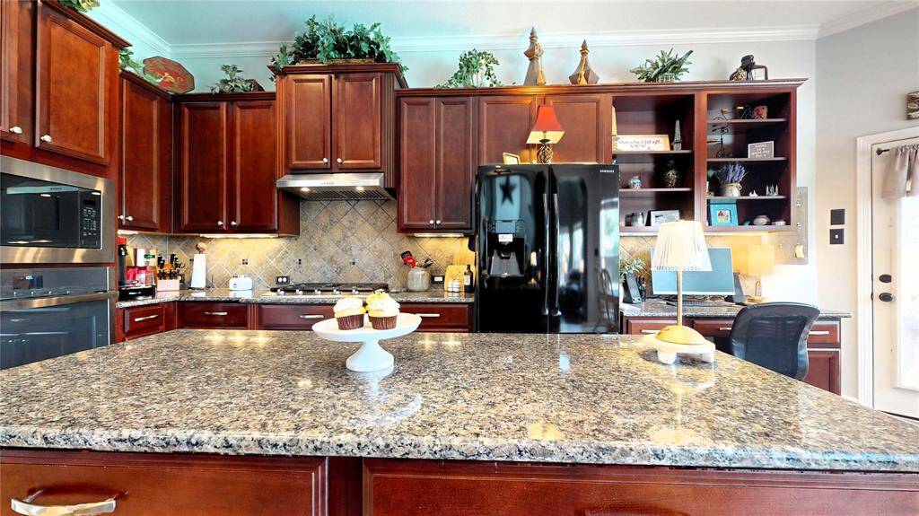 The oversized center island provides ample prep space and casual seating, perfect for everyday living or entertaining.