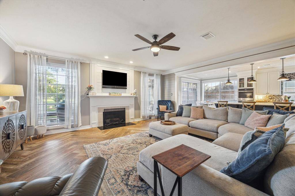 Filled with natural light, this open-concept living room features elegant flooring and a cozy fireplace. Perfect for relaxing or entertaining.