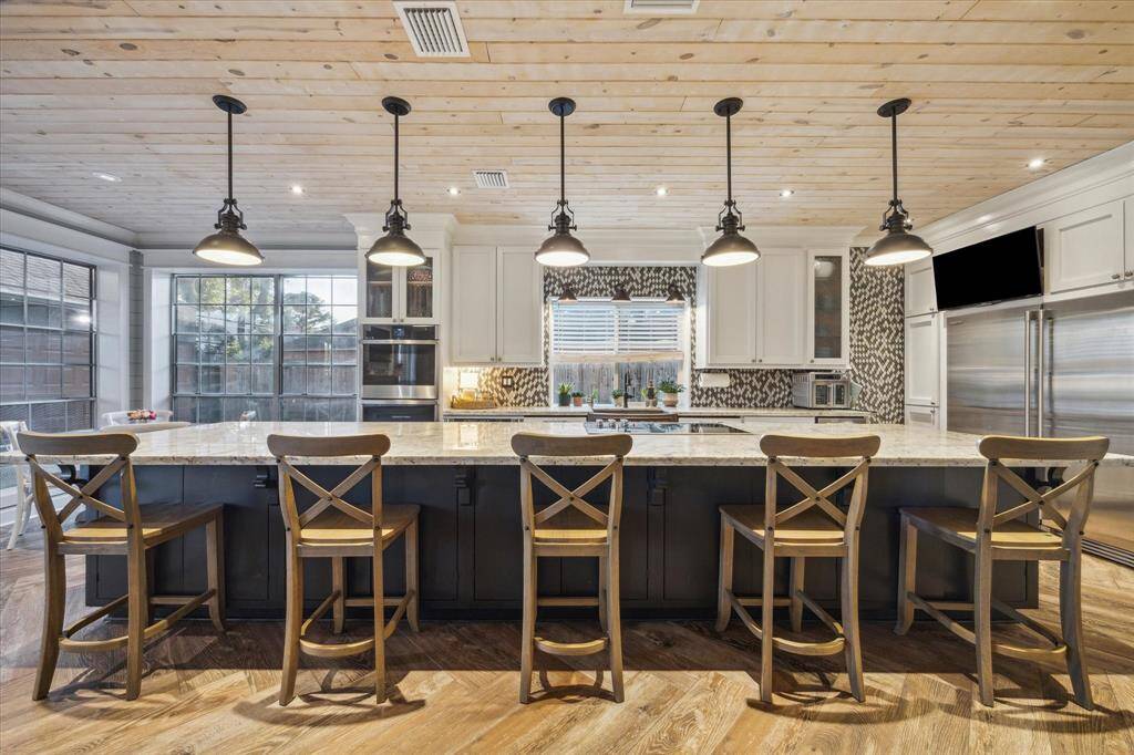 The kitchen also features a warm wood ceiling with commercial grade fridge and freezer!