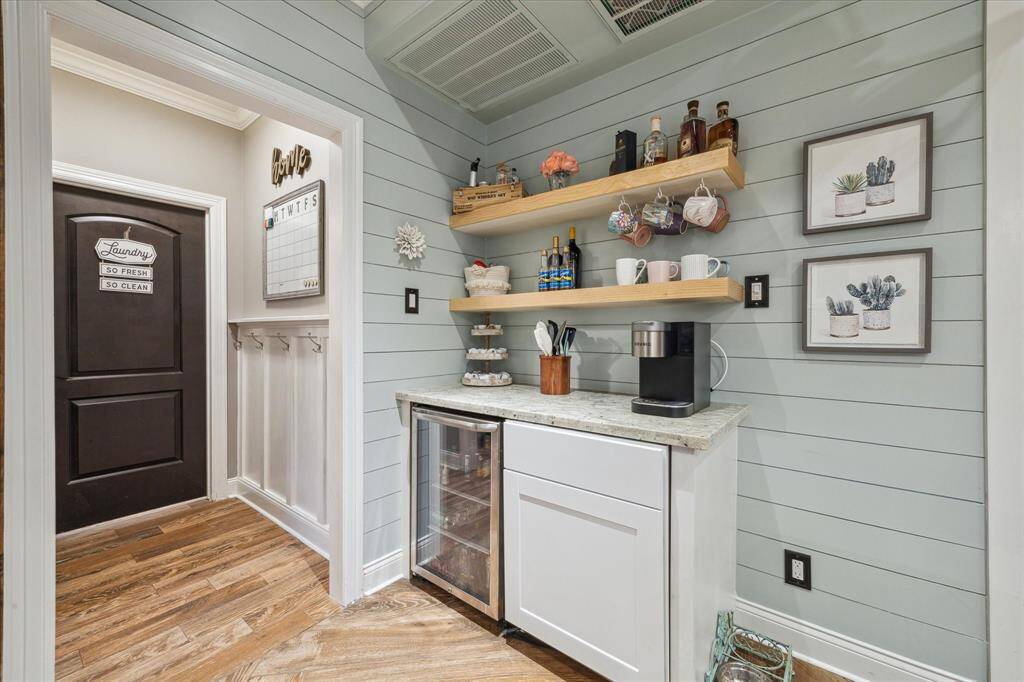 This thoughtfully designed coffee bar features a built-in water dispenser and sleek refreshment mini fridge—adding style and convenience to your daily routine.