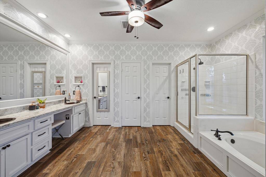 The primary bath features a spacious layout with dual vanities, a soaking tub, and separate shower—designed for comfort and relaxation.