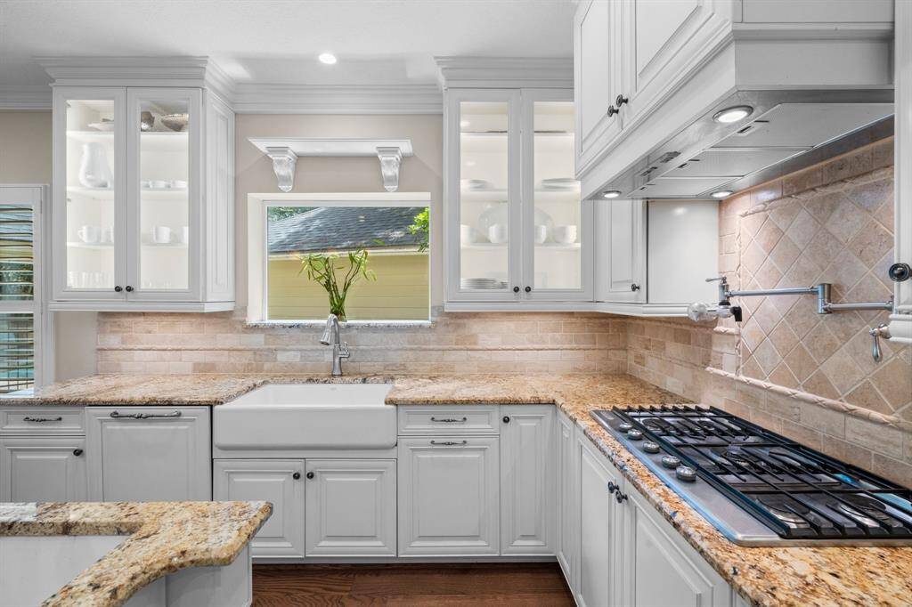 This kitchen even has a pot filler and lights inside the glass cabinets!