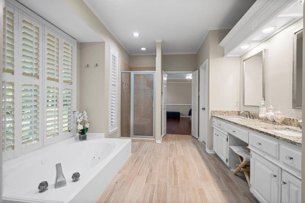 Bathroom features his/hers closets and custom built-ins.