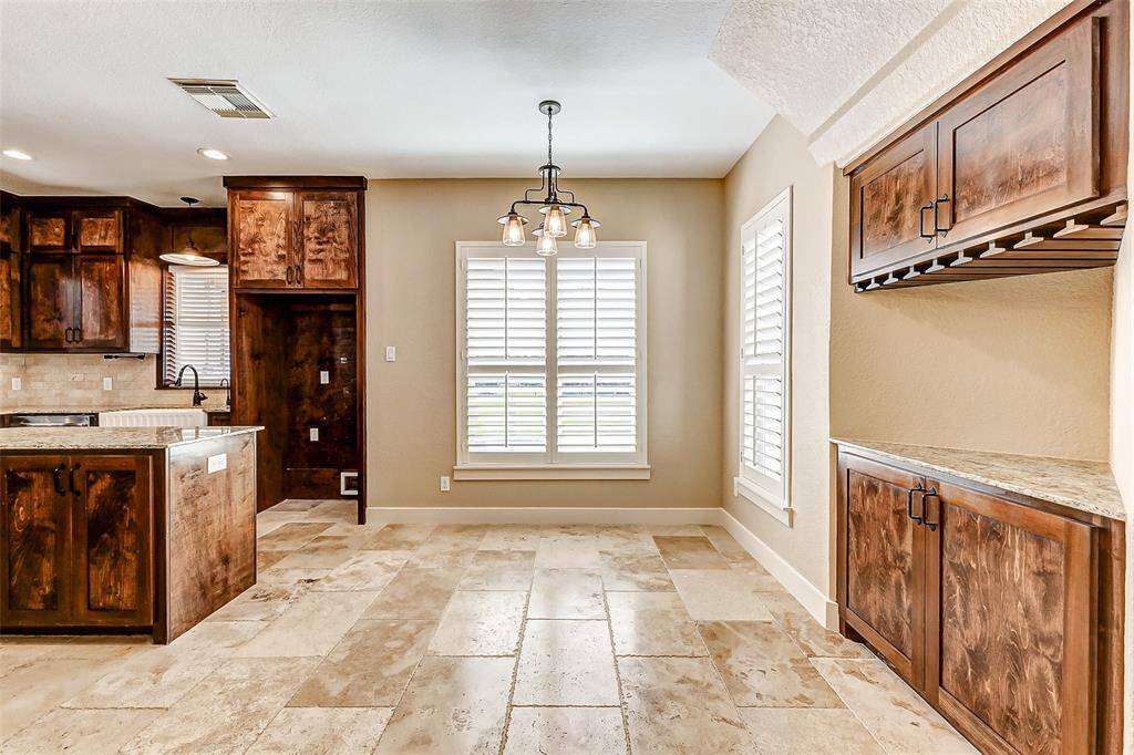This inviting breakfast nook isperfect for enjoying morningcoffee or a leisurely brunch. Thebuilt-in dry bar with wine glassholders adds a touch ofsophistication and is ideal forentertaining guests. The largewindows with plantation shuttersallow plenty of natural light to fillthe space.