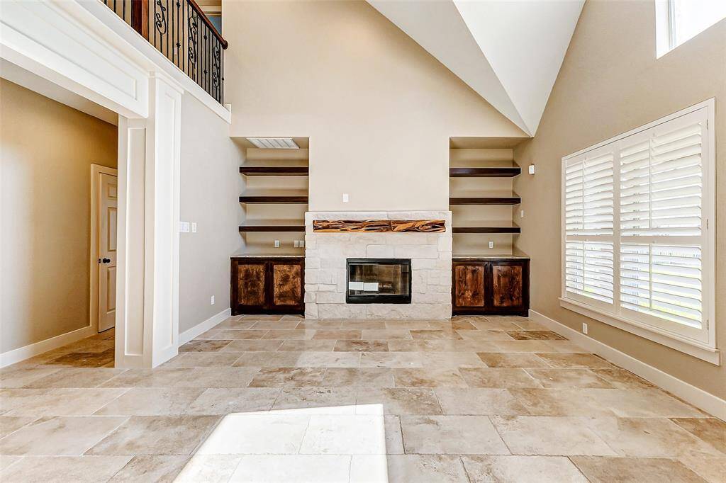 The heart of the living space isaccentuated by a fireplace andcustom built ins, creating a warmand inviting ambiance. A closerlook at the gas-log fireplaceshows a stone surround with acustom mantle.