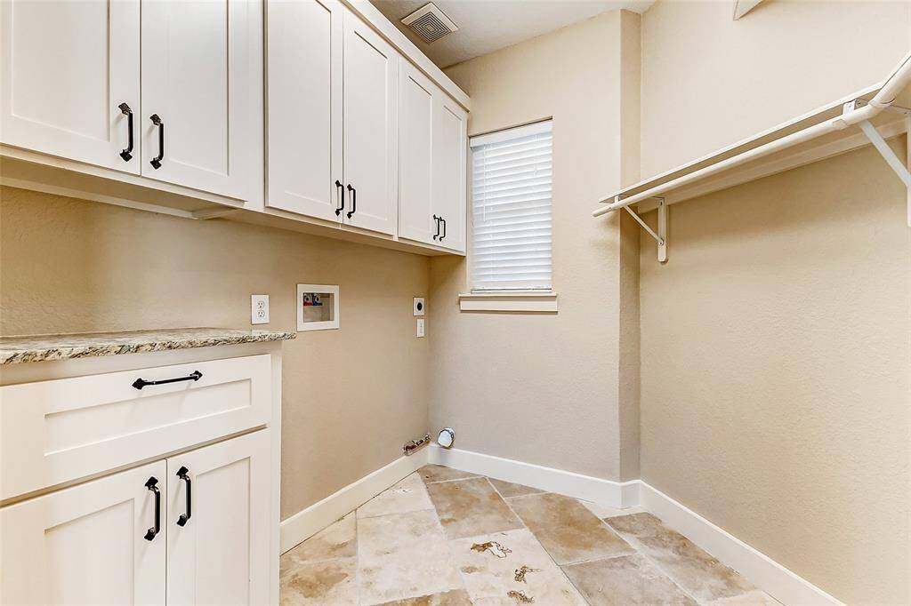 This functional laundry room isdesigned for efficiency. Theupper cabinets provide amplestorage for laundry supplies,while the lower cabinet with acountertop offers a workspacefor folding clothes. The hangingrod and neutral flooring completethis functional and stylish space.
