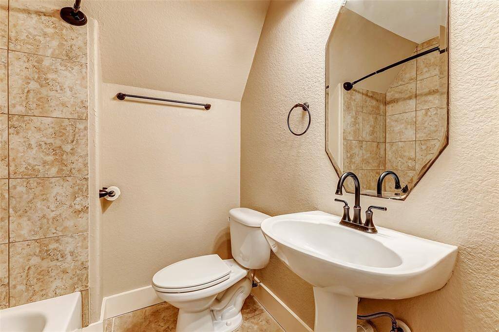 This charming guest bathroom offers both style and functionality, featuring a classic pedestal sink, a sleek commode, and a convenient shower/tub combination. With its clean design and practical layout, it’s the perfect space for guests to feel right at home.