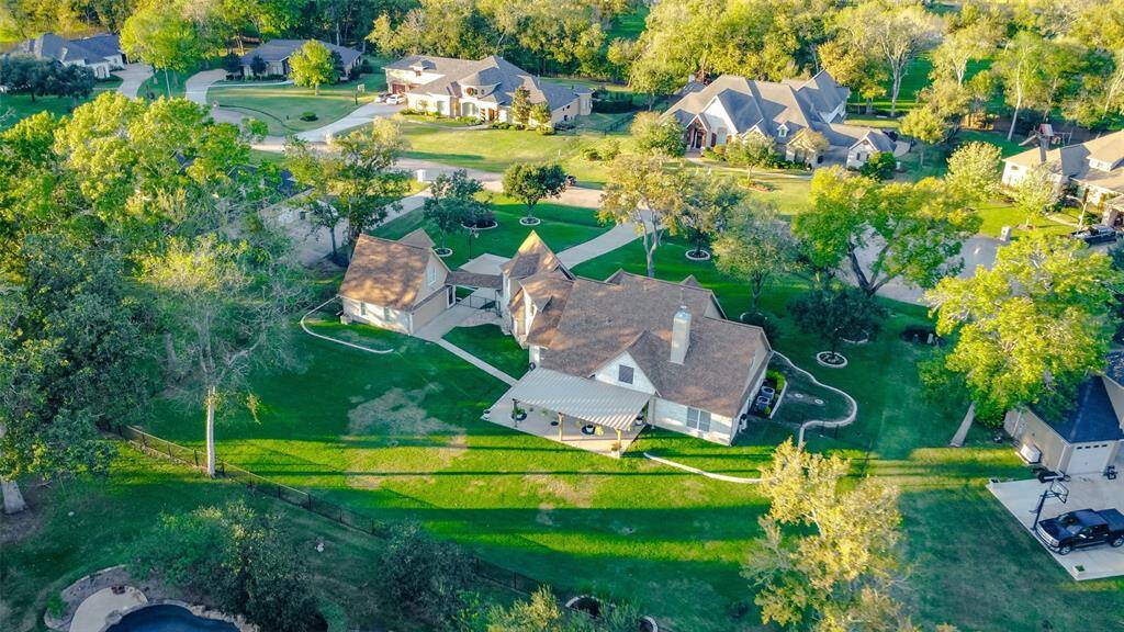 This picturesque property boasts a beautiful backyard with a large lawn, mature trees, and a covered patio, perfect for enjoying the outdoors. The home's unique architecture adds to its curb appeal.
