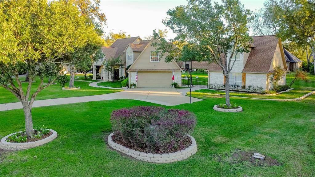 Surrounded by mature trees, the property features a meticulously landscaped front yard with lush green grass and bordered flower beds. With its inviting curb appeal and spacious layout, this home is a perfect blend of warmth and sophistication.