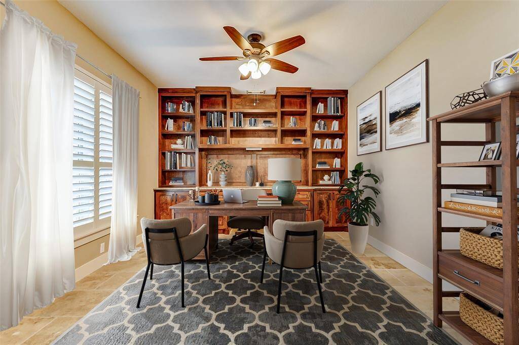 This spacious home office offersa built-in desk and a wall ofcustom cabinetry, perfect fororganizing books, files, and otheroffice essentials. The largewindows with plantation shuttersallow plenty of natural light to fillthe room, while the ceiling fanprovides comfortable airflow. Thetravertine flooring adds a touchof elegance and is easy tomaintain. *Virtually Staged