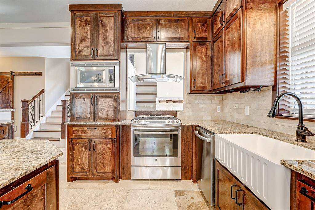Some of the appliances includea gas range with acomplementing vent hood, a builtin microwave, and a stainlesssteel dishwasher. The singlebasin sink is situated under alarge window that overlooks theexpansive backyard!
