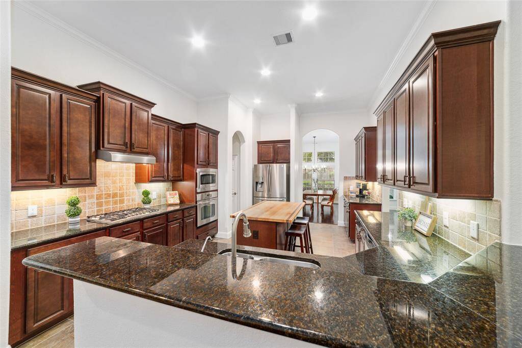 Large kitchen complete with granite counter tops, center island, stainless steel appliances, and walk in pantry.