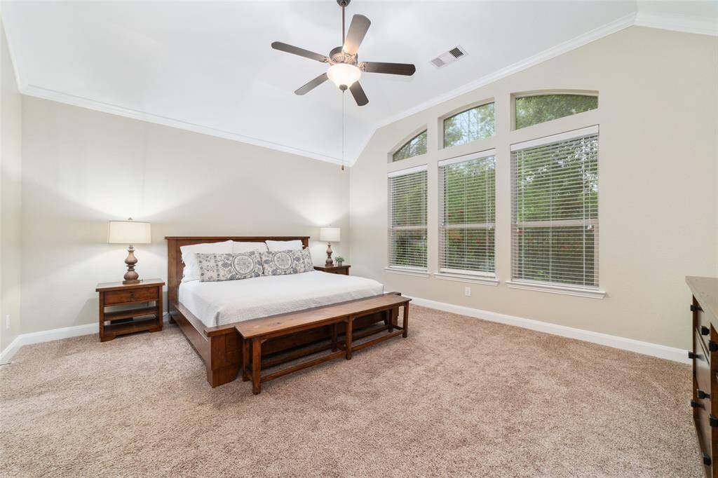 Large primary bedroom with views of nature out the windom.