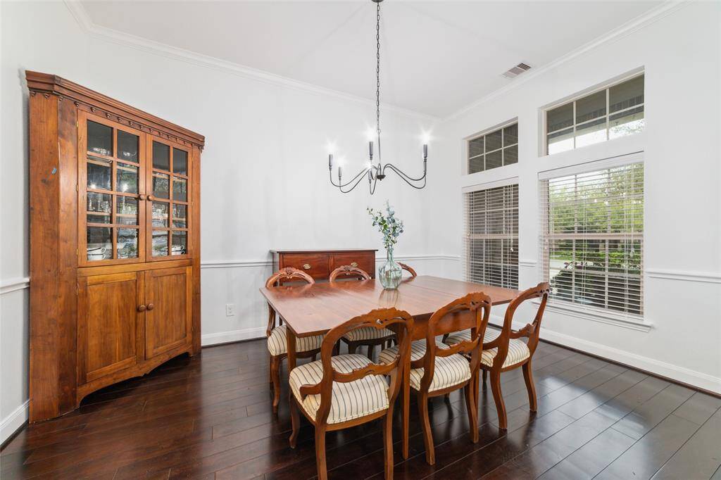 To the right is the formal dining room with wood floors, updated lighting, neutral paint colors and access into the kitchen.