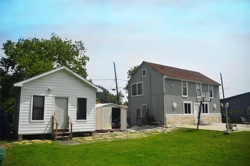 Detached cottage outbuilding with pitched roof, front steps, and adjacent storage shed—perfect for workshop, studio, or guest quarters.