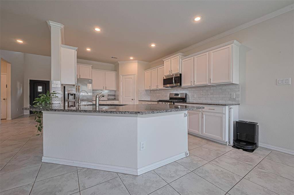 The large center island with breakfast bar seating overlooks the family room, perfect for entertaining or everyday family interaction