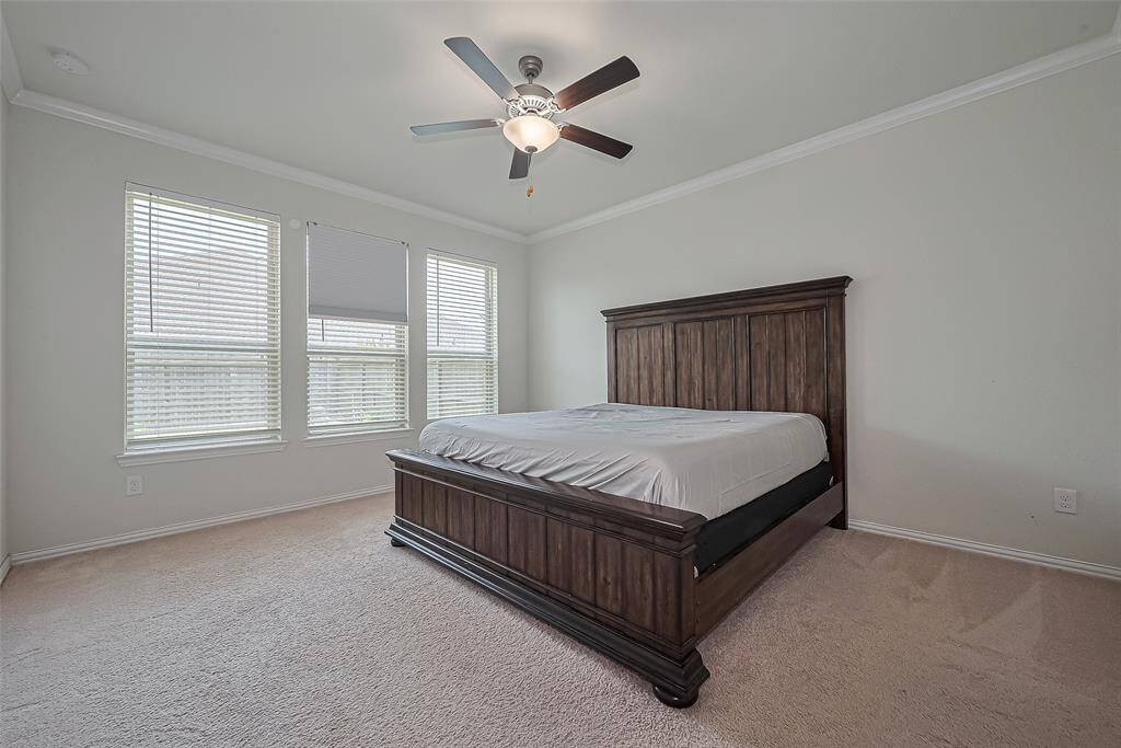 This generously sized bedroom features large windows that flood the space with natural light, creating an airy and inviting atmosphere.