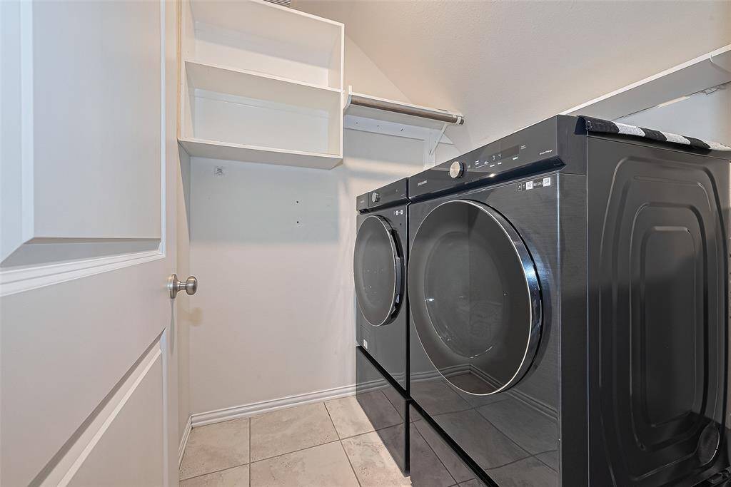 This well-appointed washing area offers ample space for a washer and dryer, along with additional storage options to keep detergents and supplies organized. Bright and efficient, it makes household chores easier and more manageable.
