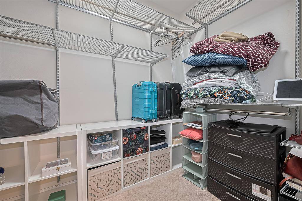 This well-appointed closet offers generous storage with plenty of room for clothing, shoes, and accessories.