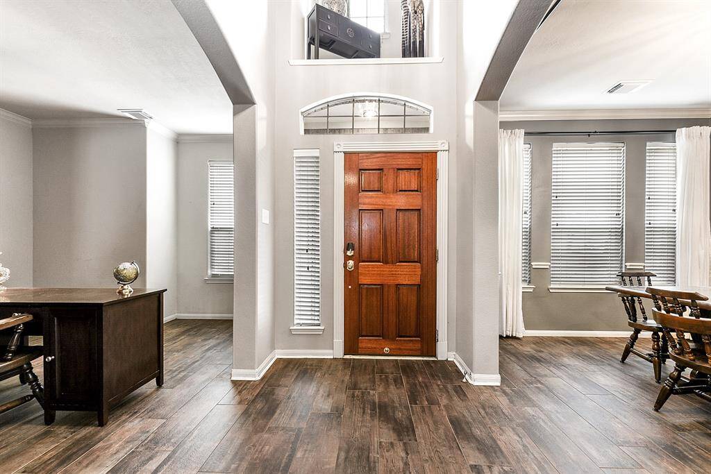 As you enter the home, you’re greeted by a grand foyer with double-height ceilings and abundant natural light streaming through tall windows, creating an impressive and welcoming atmosphere. To the right, you’ll find a formal dining room, perfect for hosting dinner parties and special occasions. To the left, there’s a den, ideal for an additional seating area or a home office.