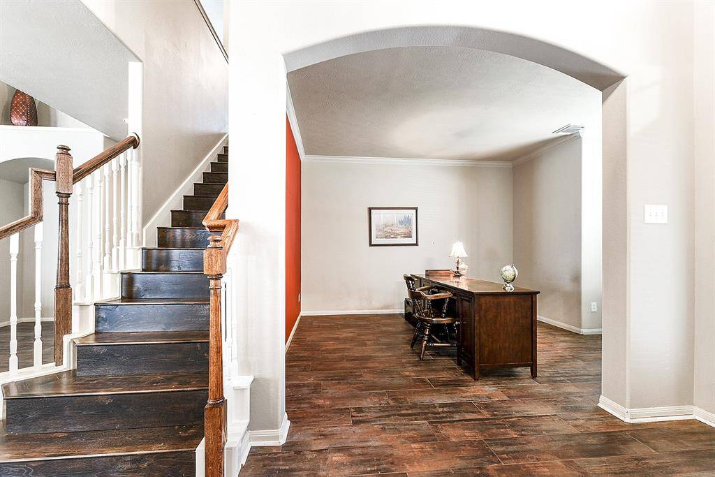 As you walk in, to the right, you’ll find a beautiful wooden staircase that adds elegance and charm to the entryway. Adjacent to the staircase is a large den, perfect for an office or an additional sitting area. The space features arched entryways, and if a more formal office is desired, French doors would frame the area easily of needed.