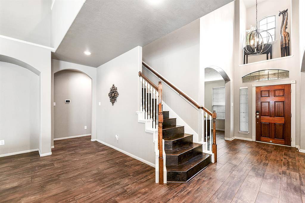 Staircased past the grand entryway, you’ll notice the home’s elegant layout. Next to the staircase, a hallway leads to the laundry room and a powder room, offering both convenience and functionality for daily living and entertaining guests.