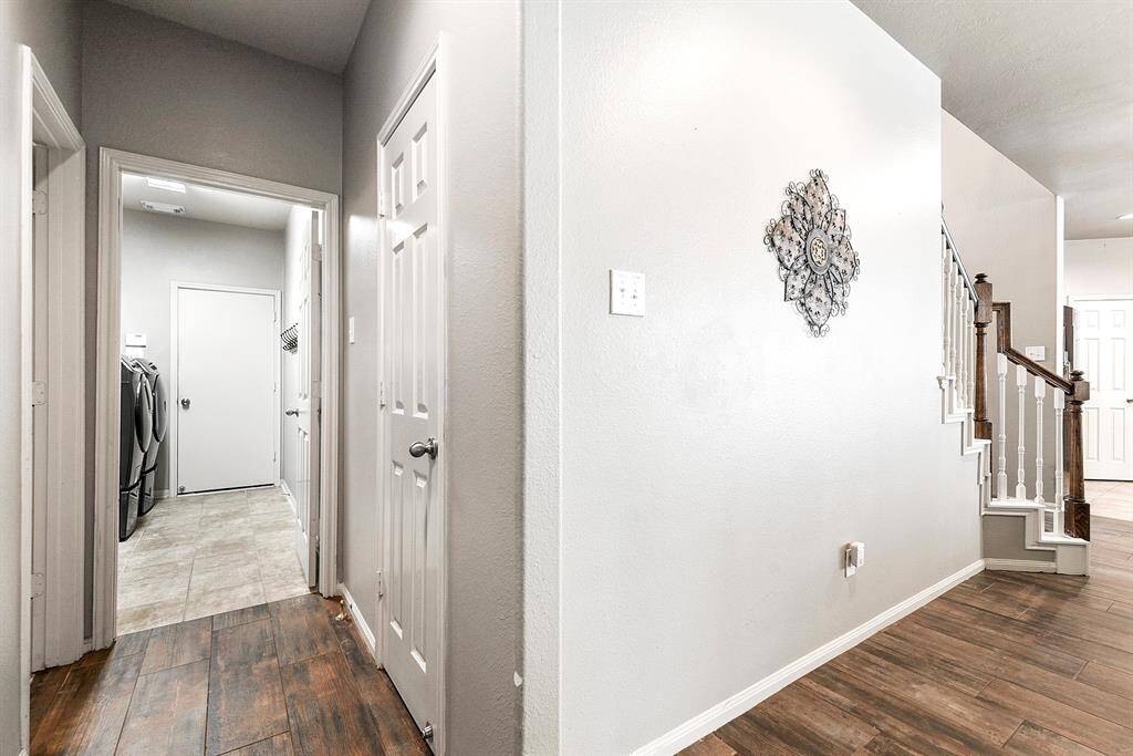 Down the hallway, you’ll find a spacious laundry room that offers plenty of room for all your laundry needs. It features a convenient pass-through design, providing easy access to the oversized two-car garage
