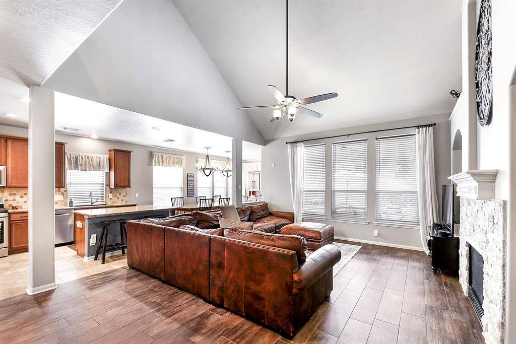 This open-concept living room, kitchen, and breakfast area creates a spacious and inviting atmosphere. The A-frame ceiling height enhances the sense of openness, while the drop-down ceiling fan provides comfort and style. Endless windows offer breathtaking views of the backyard oasis, seamlessly blending indoor and outdoor living for the ultimate relaxation and entertainment experience.
