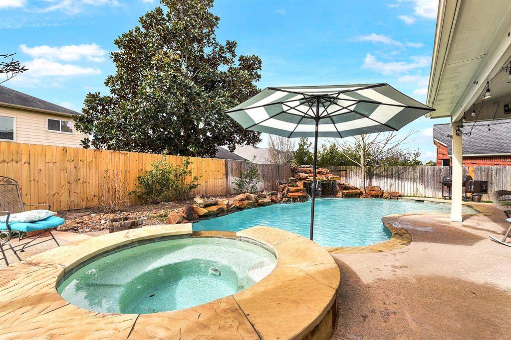 The backyard is a true retreat, featuring an amazing pool and spa with jumping rocks and a serene waterfall feature. The extended patio provides the perfect space to enjoy the beautiful outdoor views while relaxing in the shade.