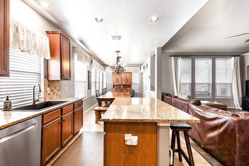 This spacious kitchen is designed to accommodate multiple chefs, making meal prep a breeze. It features a farmhouse-style sink positioned beneath a large window, offering pleasant views and plenty of natural light. The layout provides easy access to the oversized breakfast room, creating a seamless flow for cooking, dining, and entertaining.
