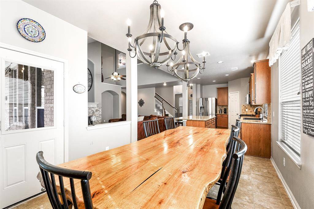 A view from the breakfast room showcases its generous size, easily accommodating a large dining table and enhanced by two elegant double chandeliers, creating a warm and inviting atmosphere. The home offers a total of three dining spaces