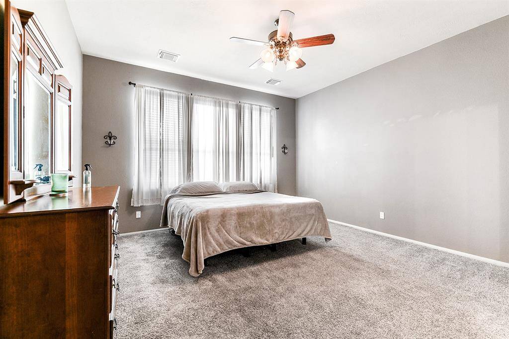 All bedrooms are generously sized, with this Primary bedroom featuring plush carpet (only 2 rooms with carpet), high ceilings with ceiling fans, and window treatments.