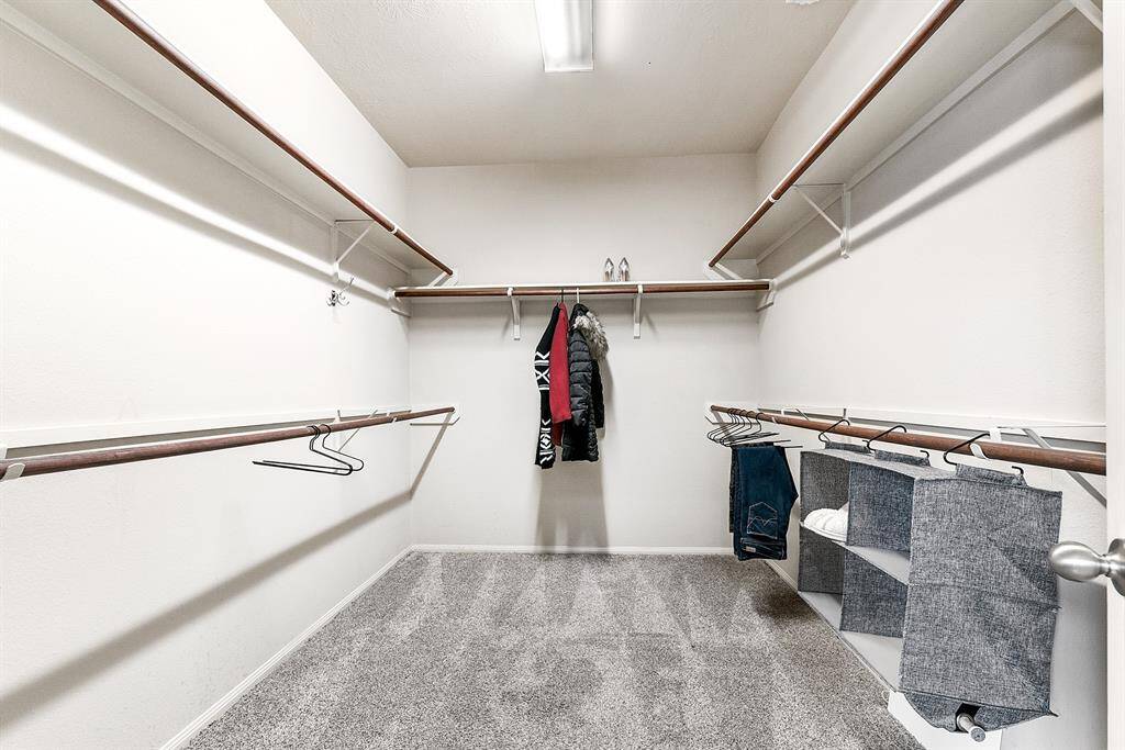 A large walk-in wardrobe typically features hanging rods and shelving designed to accommodate all your storage needs. The hanging rods allow for organized placement of clothes like dresses, shirts, and suits, while the shelving provides space for folded items, shoes, accessories, and more.